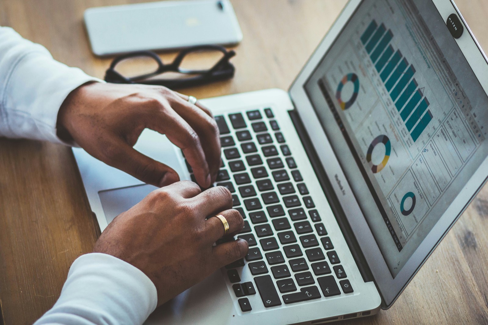 Person analysiert Finanzdiagramme auf einem Laptop